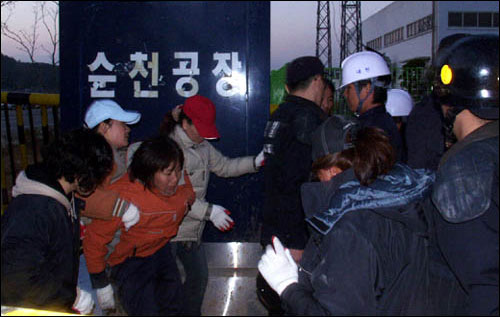 1일 밤 현대하이스코 순천공장 농성자에게 음식물과 물을 주기 위해 기다리고 있다가 경찰의 저지를 뚫고 정문 안으로 진입을 시도하는 가족들. 